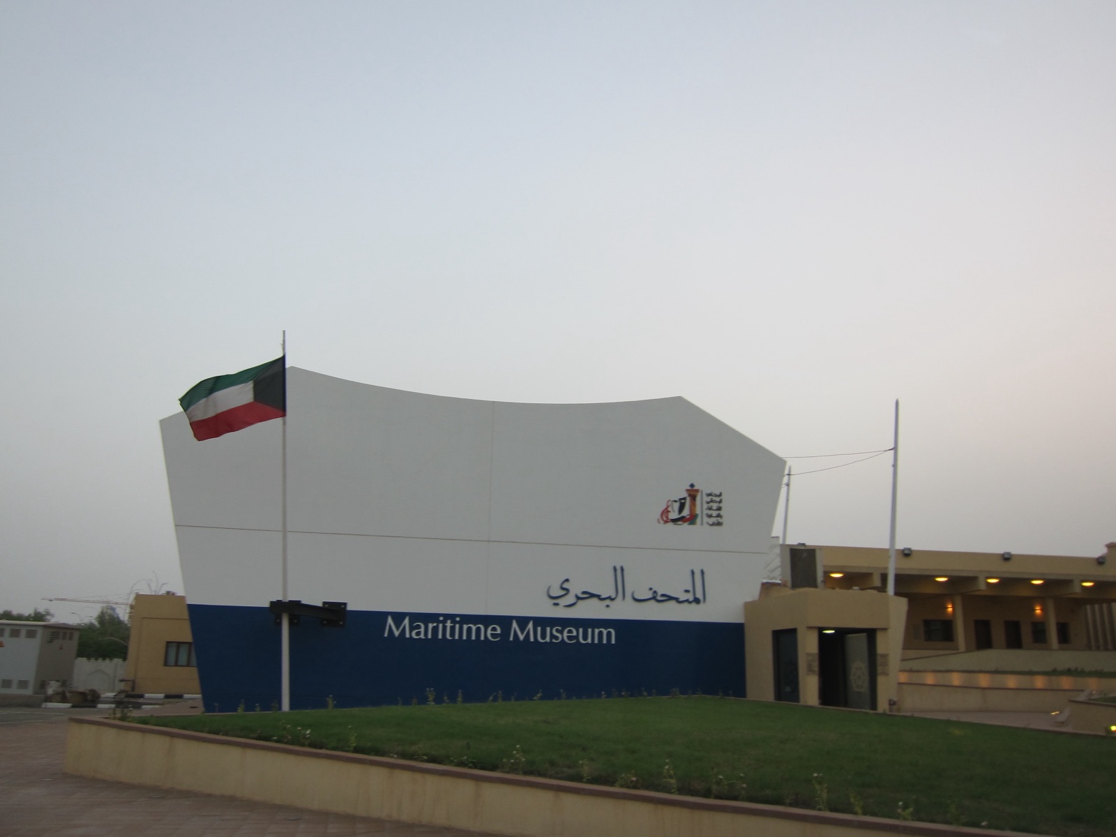 Kuwait Maritime Museum building with two large traditional wooden vessels displayed outside